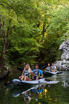 A group of friends enjoying having fun and kayaking while exploring the calm river, surrounding forest and large natural river canyons.