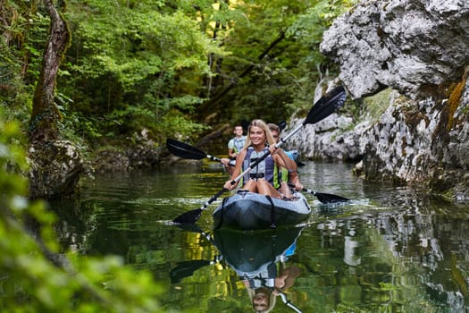 A group of friends enjoying having fun and kayaking while exploring the calm river, surrounding forest and large natural river canyons.