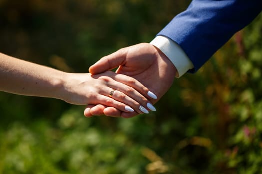 gold wedding rings in the hands of the newlyweds