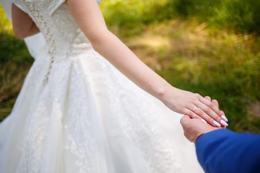 gold wedding rings in the hands of the newlyweds