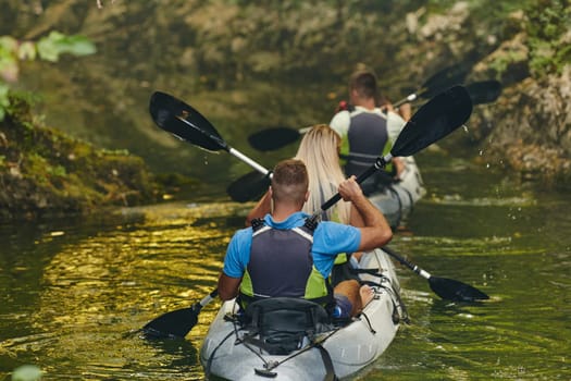 A group of friends enjoying having fun and kayaking while exploring the calm river, surrounding forest and large natural river canyons.