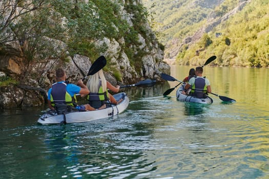 A group of friends enjoying having fun and kayaking while exploring the calm river, surrounding forest and large natural river canyons.