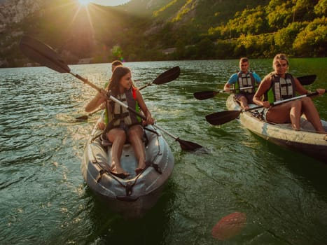 A group of friends enjoying fun and kayaking exploring the calm river, surrounding forest and large natural river canyons during an idyllic sunset