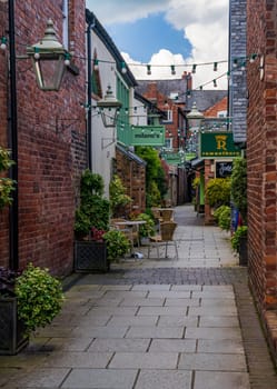 Oswestry, Shropshire - 12 May 2023: Shops and cafes along Old Chapel Court in market town of Oswestry