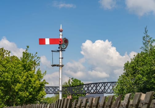 Old railway signal set to stop in Oswestry Shropshire against blue sky