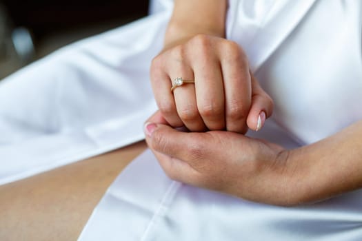 gold wedding rings in the hands of the newlyweds