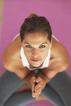 Yoga is an all-natural detox. High angle shot of a young woman practicing yoga at home