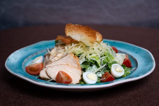 Caesar salad with chicken, fresh lettuce leaves and baked bread.