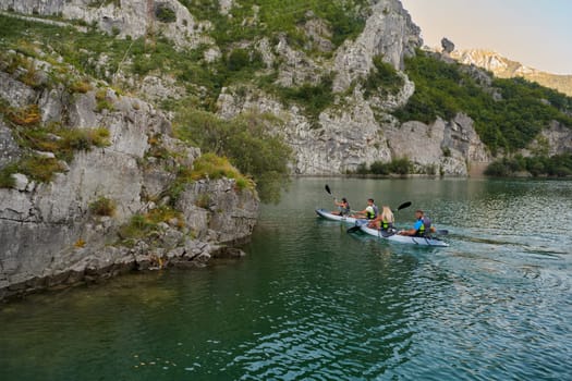 A group of friends enjoying having fun and kayaking while exploring the calm river, surrounding forest and large natural river canyons.