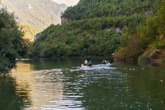 A group of friends enjoying having fun and kayaking while exploring the calm river, surrounding forest and large natural river canyons.