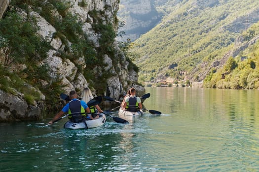 A group of friends enjoying having fun and kayaking while exploring the calm river, surrounding forest and large natural river canyons.