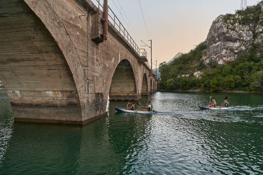 A group of friends enjoying having fun and kayaking while exploring the calm river, surrounding forest and large natural river canyons.