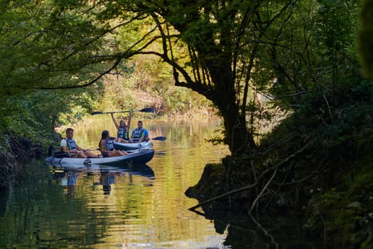 A group of friends enjoying having fun and kayaking while exploring the calm river, surrounding forest and large natural river canyons.