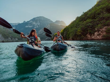 A group of friends enjoying fun and kayaking exploring the calm river, surrounding forest and large natural river canyons during an idyllic sunset