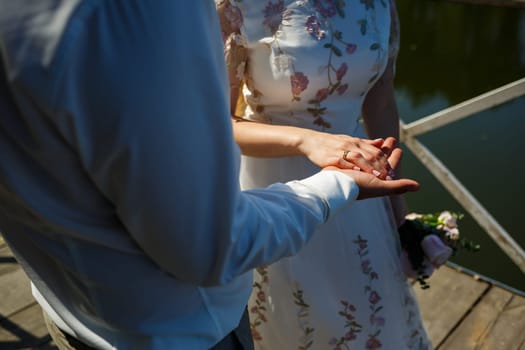 gold wedding rings in the hands of the newlyweds