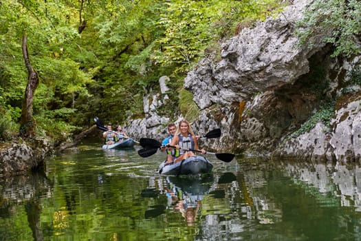 A group of friends enjoying having fun and kayaking while exploring the calm river, surrounding forest and large natural river canyons.