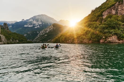 A group of friends enjoying fun and kayaking exploring the calm river, surrounding forest and large natural river canyons during an idyllic sunset