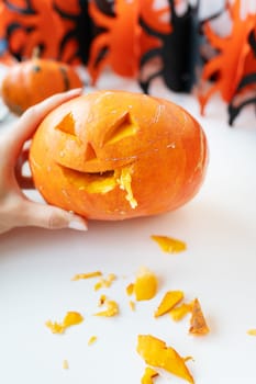 October 31. Halloween holiday. The carved face of a pumpkin on an orange and black background