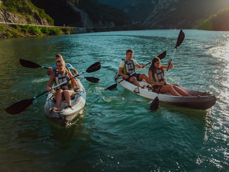 A group of friends enjoying fun and kayaking exploring the calm river, surrounding forest and large natural river canyons during an idyllic sunset