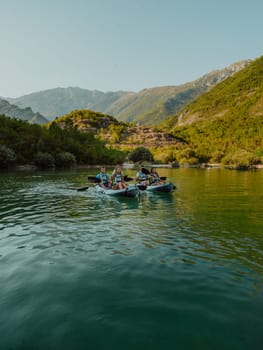 A group of friends enjoying having fun and kayaking while exploring the calm river, surrounding forest and large natural river canyons.