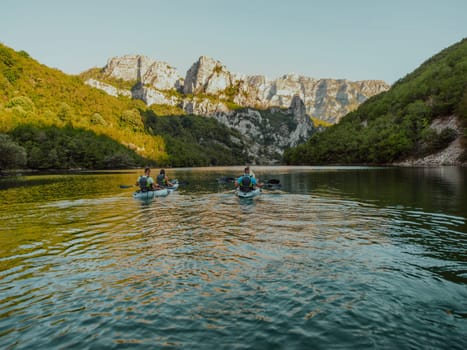 A group of friends enjoying having fun and kayaking while exploring the calm river, surrounding forest and large natural river canyons.