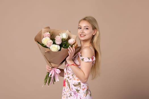 front view young female holding bouquet of beautiful roses on brown background feminine woman horizontal march gift marriage equality