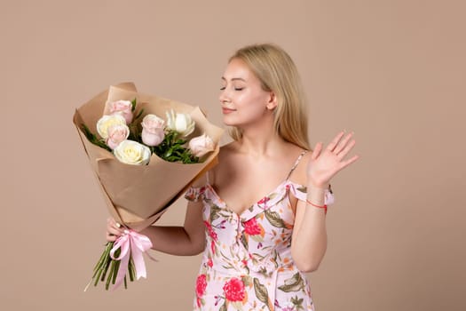 front view young female posing with bouquet of beautiful roses on brown background feminine sensual horizontal march gift marriage equality