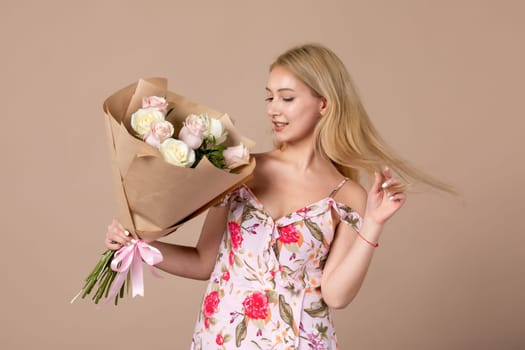 front view young female posing with bouquet of beautiful roses on brown background feminine sensual horizontal march marriage equality woman gifts