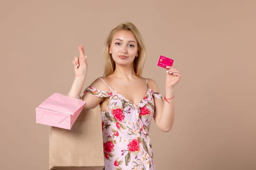 front view young female with present packages and bank card on brown background feminine sensual horizontal march marriage woman money equality