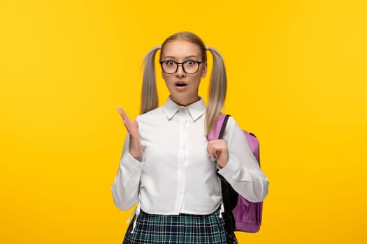 world book day blonde girl with ponytails and pink backpack on yellow background