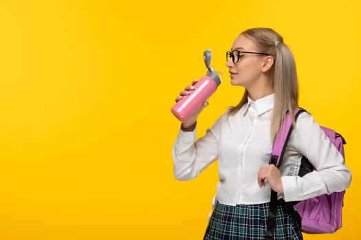world book day blonde school girl in cute uniform drinking from pink thermos
