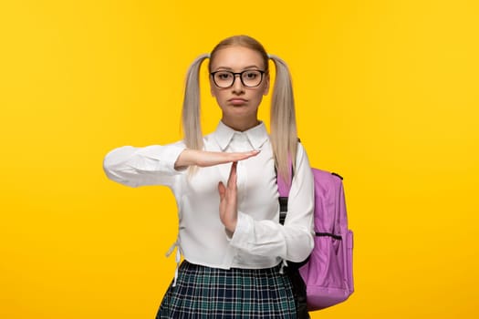 world book day blonde school girl showing stop sign with hands and pink backpack