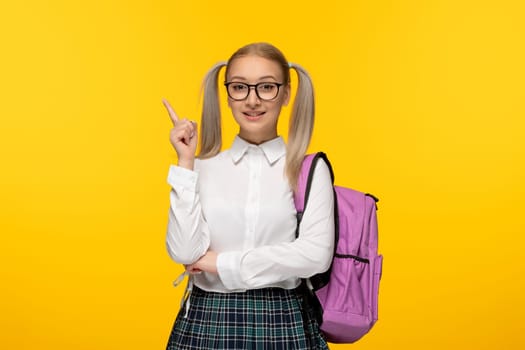 world book day blonde schoolgirl pointing up with pink backpack