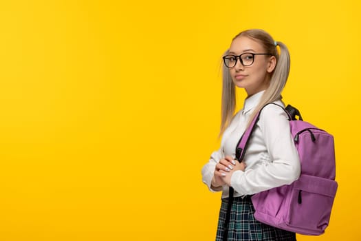 world book day blonde student with pony tails and glasses on yellow background