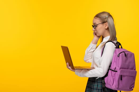 world book day blonde student with pony tails holding a computer