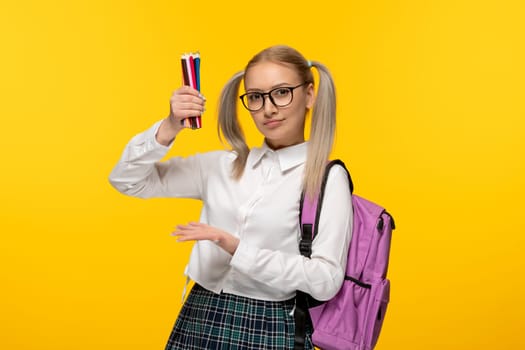 world book day blonde student with pony tails holding many pencils