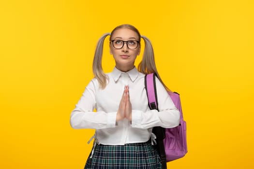 world book day blonde young girl praying hands together on yellow background