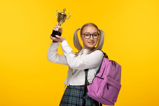 world book day excited blonde schoolgirl on yellow background holding a price