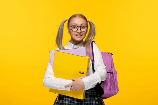 world book day happy schoolgirl holding yellow folder with pink backpack