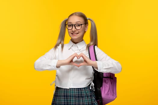 world book day happy schoolgirl in glasses with pink backpack