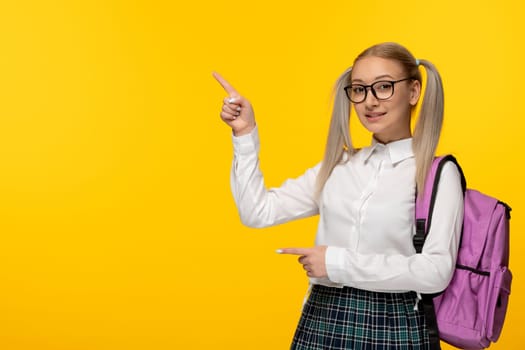 world book day happy schoolgirl with ponytails wearing pink backpack and glasses