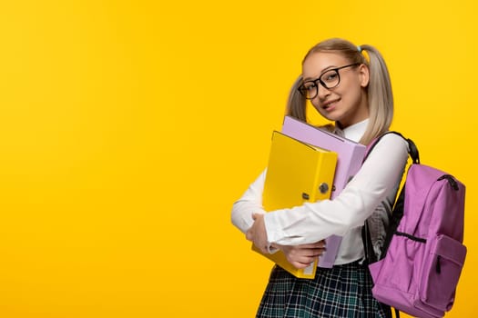world book day happy smiling blonde school girl holding folders and pink backpack