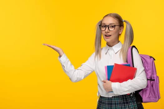 world book day happy smiling blonde schoolgirl holding books with backpack