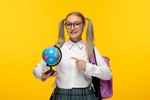 world book day happy smiling school girl with backpack holding a blue globus