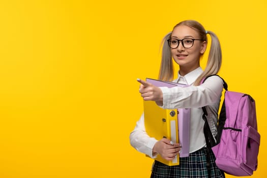 world book day school girl with glasses pointing left with pink backpack