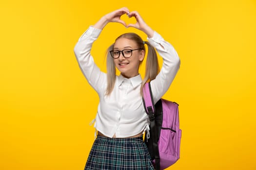 world book day schoolgirl cute showing heart with hands with pink backpack