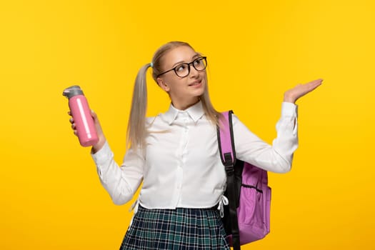 world book day schoolgirl with pony tails holding pink thermos and backpack