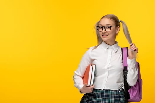 world book day smiling cute student in uniform holding books and pink backpack