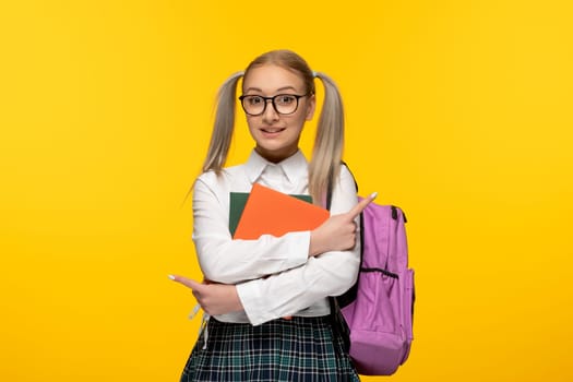 world book day smiling happy student holding books and a pink backpack