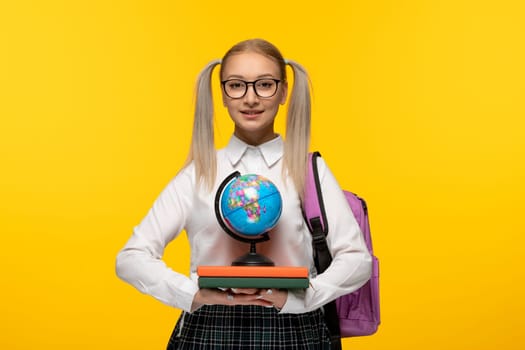 world book day smiling smart schoolgirl with pony tails holding books and globus